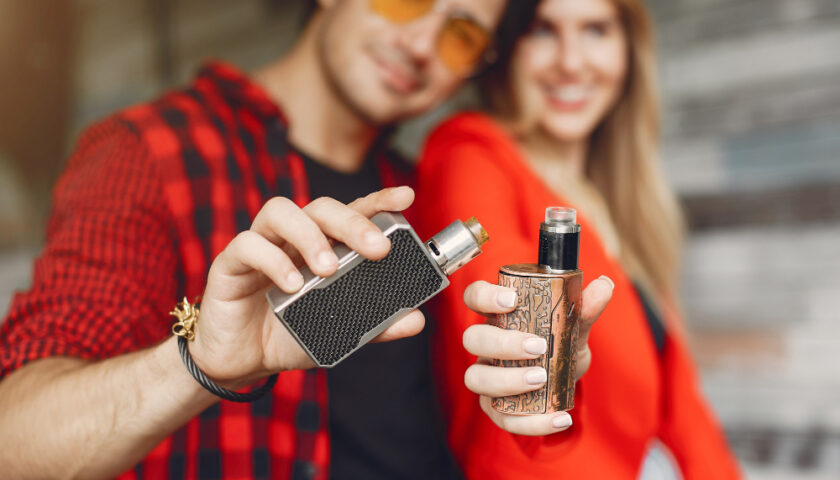 un couple souriant avec une vapoteuse